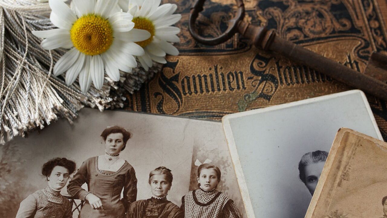 Fotografii vechi de familie, alb-negru, așezate lângă un scaner pe o masă de lucru